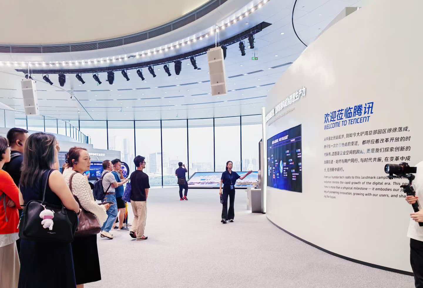 沃瑞斯科技带领企业家参访腾讯展厅，讲解员在欢迎莅临腾讯展墙前讲解腾讯发展历程